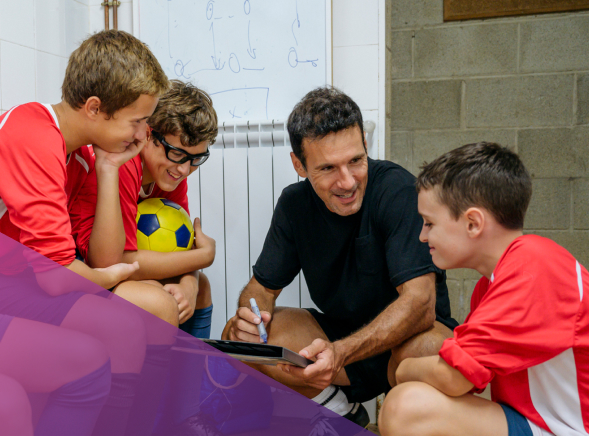 Young boys listening to adult coach speak